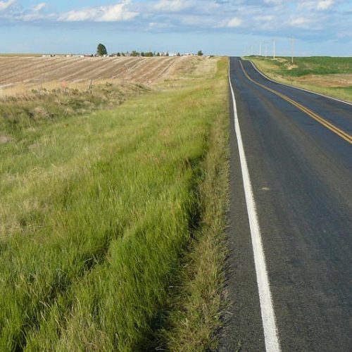 Paved highway running along a field